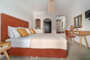 a bedroom with a large bed with a desk and a chair at Margi House in Skiathos Town