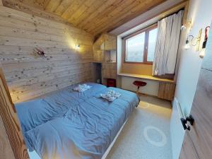 a bedroom with a blue bed in a wooden wall at Chalet Avoriaz, 6 pièces, 10 personnes - FR-1-314-100 in Avoriaz
