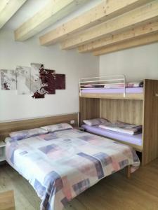 2 letti a castello in una camera con soffitti in legno di B&B Al Portico a Telve