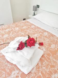 a bouquet of red roses sitting on a bed at Ubetty village center two-bedrooms apartment 5terreparco in Riomaggiore
