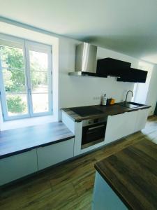 a kitchen with white cabinets and a stove top oven at Gte du moulin brochat avec espace jacuzzi commun in Saint-Jean-de-Vaux