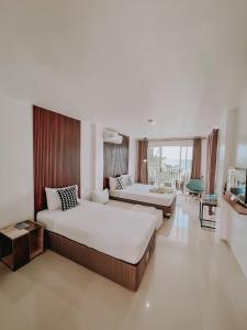 a hotel room with two beds and a television at A Villas Resort & Restaurant in Zamboanguita +70 photos