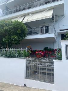a white building with a balcony with flowers on it at Anna House 2 in Sarti