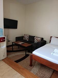 a living room with a bed and a couch at Emeli Suites in Nairobi