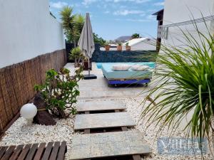 un pequeño patio trasero con sofá y sombrilla en VILLAZUL by Villitas, en Playa Blanca
