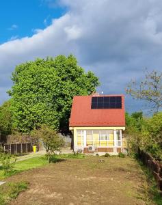 une maison dotée d'un toit rouge avec des panneaux solaires dans l'établissement Domek na uboczu, studio z tarasem, à Cracovie