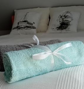 niebieski ręcznik z białym łukiem na łóżku w obiekcie Domki Grażyna w Jastarni