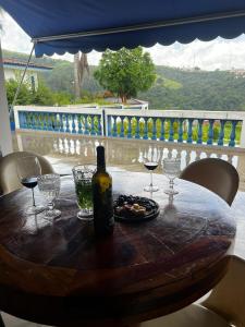 een fles wijn op een tafel met wijnglazen bij Chácara das Araras in Lindóia