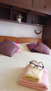 un par de gafas sentadas encima de una cama en apartmani DIMIĆ, en Supetar