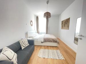 un soggiorno bianco con divano e letto di 130qm - 2 Apartments side by side - free parking - city - MalliBase Apartments ad Hannover