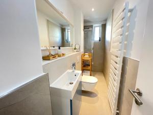 un bagno bianco con un water e un lavandino di 130qm - 2 Apartments side by side - free parking - city - MalliBase Apartments ad Hannover