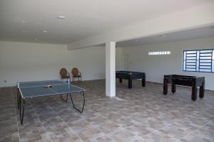 a room with two tables and a ping pong table at Chácara das Araras in Lindóia