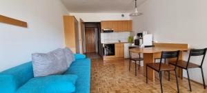 Il comprend un salon avec un canapé bleu et une cuisine. dans l'établissement Apartma Luka with private parking, à Izola