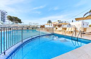 een zwembad met een hek eromheen bij Leonardo Suites Hotel Ibiza Santa Eulalia in Es Cana