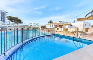 エス・カナにあるLeonardo Suites Hotel Ibiza Santa Eulaliaの周囲にフェンスを設けたスイミングプール