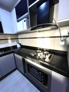 una cucina con piano cottura e forno di Cobertura Luxo Sophia I - Orla Praia Grande ad Arraial do Cabo