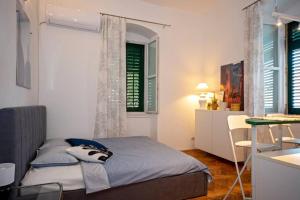 a bedroom with a bed and a table and a desk at Ora, home on the sea. in Split