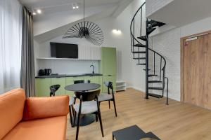 a living room with a table and a spiral staircase at Waterlane Vintage - Fitness & Gym by Downtown Apartments in Gdańsk