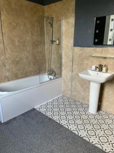 a bathroom with a tub and a sink and a shower at Glenaldor House B&B in Dumfries
