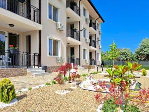 a garden in front of a building at Di Mare Holiday Apartments in Kranevo
