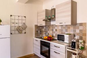 een keuken met een witte koelkast en een magnetron bij Casa Morgana-Beachfront in Roccalumera