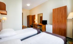 Habitación de hotel con 2 camas y escritorio en Hotel Millennium en Budapest