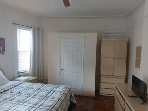 1 dormitorio con 1 cama, vestidor y TV en Crsytal Chateau Room Rental en Brooklyn