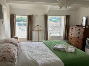 a bedroom with a bed with two towels on it at Entire characterful cottage in Calstock, Cornwall in Calstock