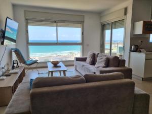 a living room with a couch and a table at Beachfront Gallery in Acre