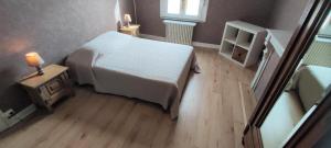 a small bedroom with a bed and a wooden floor at L'esperance 2 in Haybes