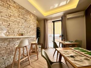 une salle à manger avec des tables et des chaises et un mur en briques dans l'établissement Amuka B&B, à Santo Stefano di Camastra