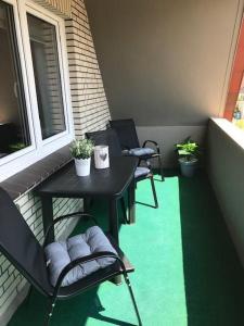 een balkon met 2 stoelen, een tafel en een raam bij Kathrin, Ferienwohnung in Schneverdingen