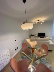 a living room with a couch and a table and chairs at Apartamentos modernos Residencial el Pinar in Liencres