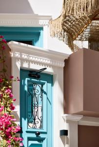 a blue door on a house with pink flowers at Syroc Maison in Ermoupoli