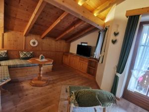 ein Wohnzimmer mit einem Sofa und einem TV in der Unterkunft Schlosserhof in Telfes im Stubai