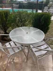 ein weißer Tisch und zwei Stühle neben einem Tisch in der Unterkunft Vivaldi Suites in Villa Carlos Paz