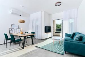 uma sala de estar com um sofá azul e uma mesa em Apartments San Maris em Umag