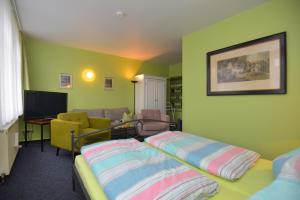 um quarto com uma cama, um sofá e uma televisão em Hotel Goldene Sonne em Arnstadt