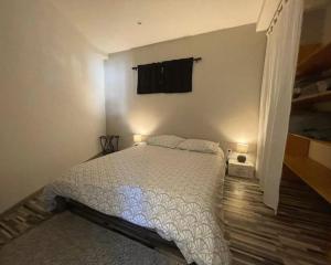 une chambre avec un lit avec une couette blanche dans l'établissement Appartement à la montagne, à Lamoura