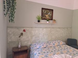 um quarto com uma cama e um vaso com plantas. em Camera Privata Vicino al Teatro Ariston em Sanremo mais 7 fotografias