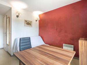 1 dormitorio con cama y pared roja en Vacancéole - Les Gentianes, en Gresse-en-Vercors