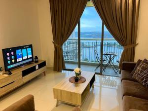 un soggiorno con TV e una grande finestra di Teega Suites Puteri Harbour_5min Legoland #6Pax (16) a Nusajaya