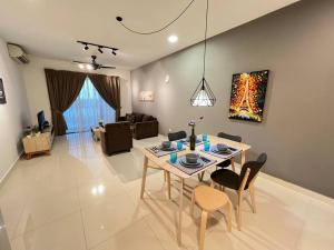 ein Esszimmer und ein Wohnzimmer mit einem Tisch und Stühlen in der Unterkunft Teega Suites Puteri Harbour_5min Legoland #6Pax (16) in Nusajaya