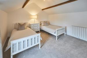 a bedroom with two beds and a lamp in it at Host & Stay - The Hay Loft in Wakefield