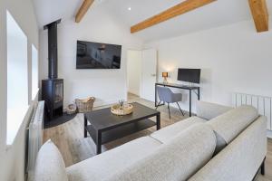 uma sala de estar com um sofá e uma lareira em Host & Stay - The Hay Loft em Wakefield