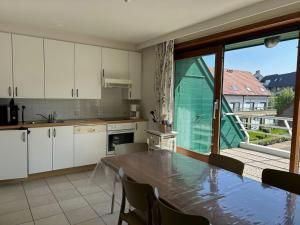 a kitchen with a table and a large window at Peppino II 0202 - 3 bedrooms 6p - penthouse sunny terraces in Sint-Idesbald