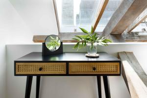 a table with a mirror and a plant in a window at RWY Suite58 Luxury 2 Bed Apartment at Royal William Yard in Plymouth