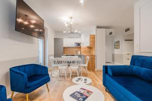 a living room with a blue couch and a table at Apartments Lipova Stegna Park Coffee&Wi-Fi- 500 m do plaży, Bezpłatny Meleks in Stegna