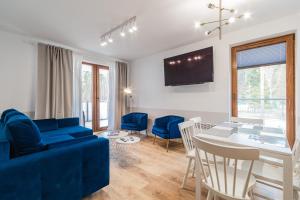 a living room with a blue couch and a table at Apartments Lipova Stegna Park Coffee&Wi-Fi- 500 m do plaży, Bezpłatny Meleks in Stegna