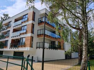 apartamentowiec z balkonem i kortem tenisowym w obiekcie Enklawa Mielno przy plaży - Szklane apartamenty w mieście Mielno